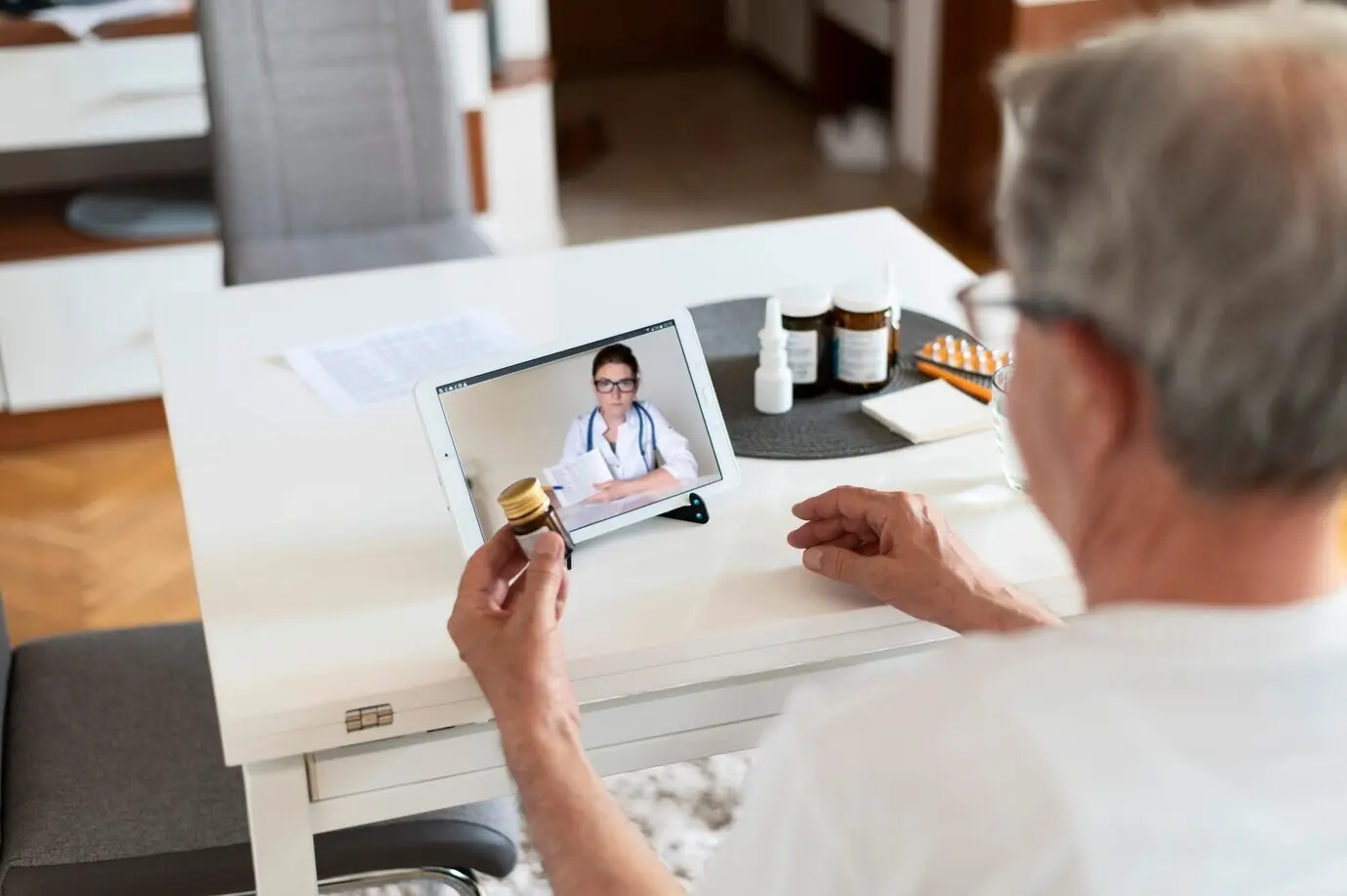 Крупный план пожилого мужчины, разговаривающего с онлайн‑врачом.